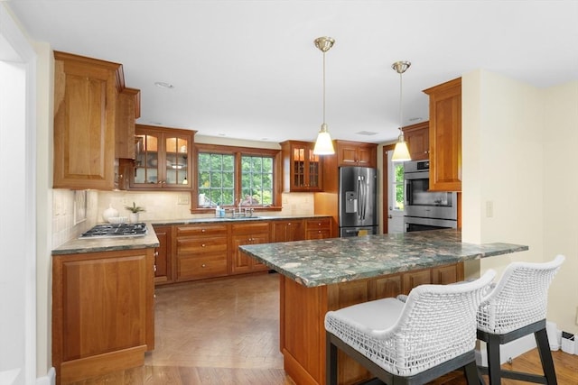 15 Hawthorne Rd, Hingham, MA 02043 - kitchen featuring appliances with stainless steel finishes, a peninsula, tasteful backsplash, and a sink