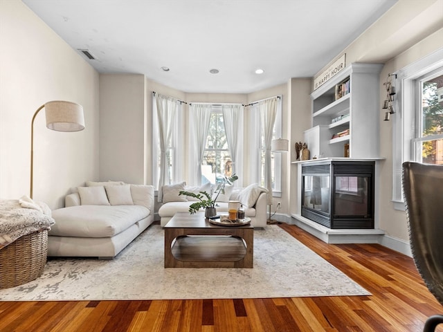 living room featuring light hardwood / wood-style floors and a multi sided fireplace