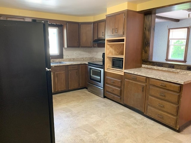 19 Locust Ave, Southbridge, MA 01550 - kitchen with freestanding refrigerator, electric stove, under cabinet range hood, and healthy amount of natural light