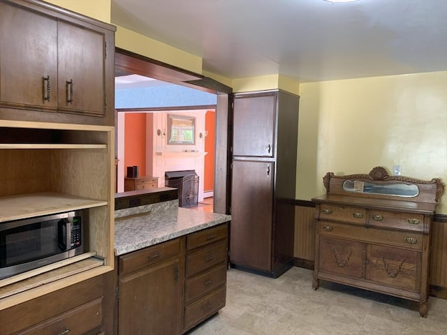 19 Locust Ave, Southbridge, MA 01550 - kitchen featuring wainscoting, dark brown cabinetry, light countertops, and stainless steel microwave
