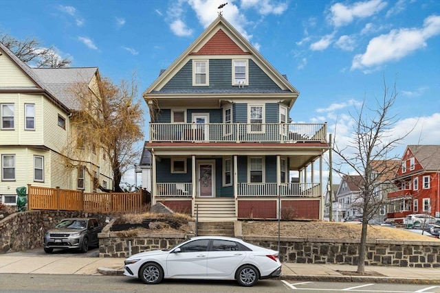 victorian house featuring covered porch and a balcony