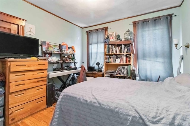 bedroom featuring ornamental molding and wood finished floors