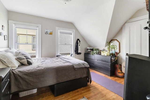 bedroom featuring lofted ceiling and wood finished floors