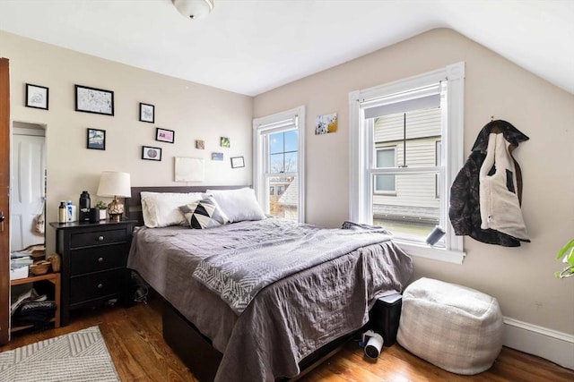 bedroom featuring wood finished floors and lofted ceiling