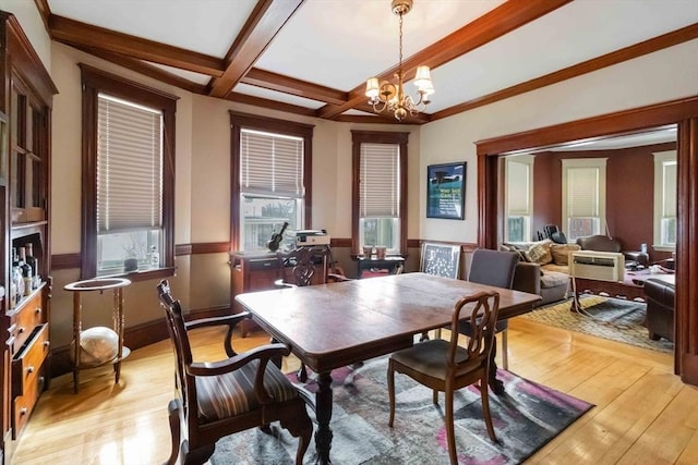 dining area featuring light wood-style flooring, beam ceiling, a chandelier, and coffered ceiling