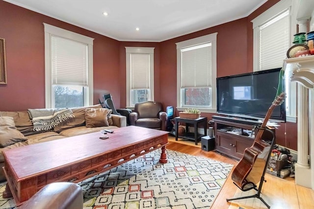 living area with crown molding, recessed lighting, and light wood-style flooring