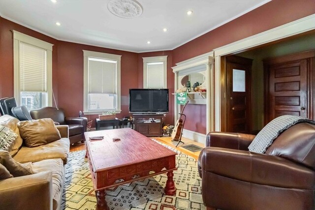 living area with recessed lighting, ornamental molding, and light wood-style flooring