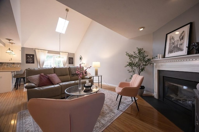 38 Nature View Dr Unit 38, Uxbridge, MA 01569 - living area featuring a skylight, light wood finished floors, a glass covered fireplace, and vaulted ceiling
