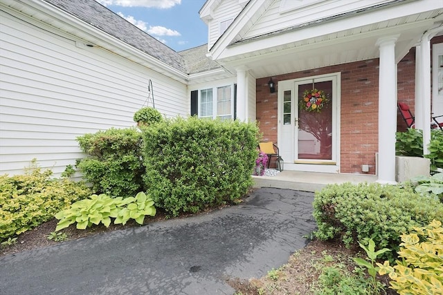 38 Nature View Dr Unit 38, Uxbridge, MA 01569 - doorway to property featuring brick siding, a porch, and roof with shingles