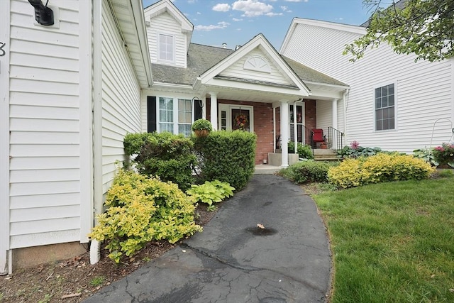 38 Nature View Dr Unit 38, Uxbridge, MA 01569 - property entrance with covered porch, roof with shingles, and brick siding