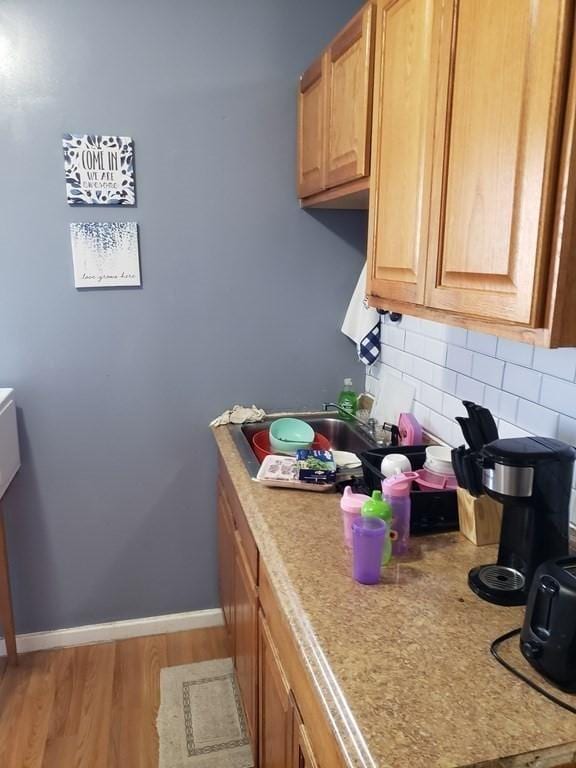 kitchen featuring tasteful backsplash and light hardwood / wood-style flooring