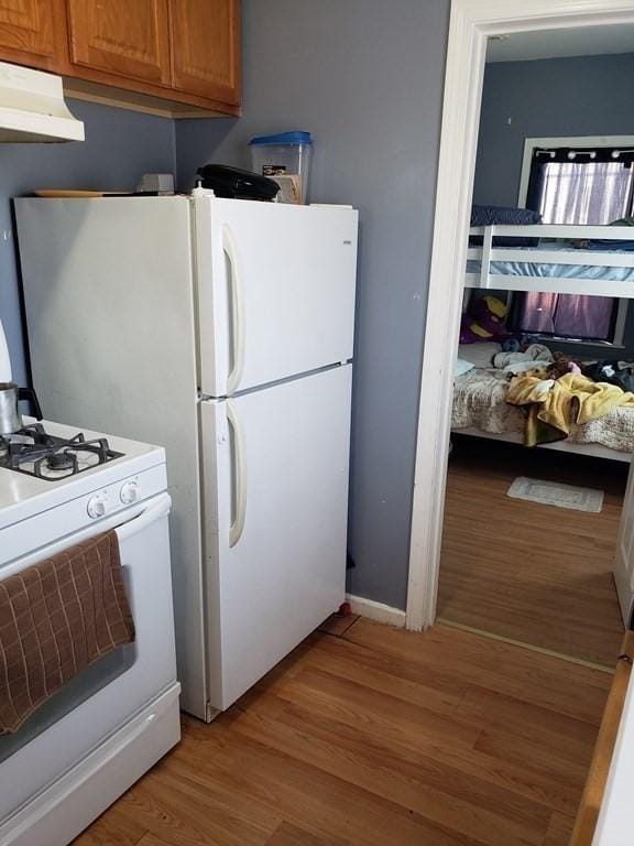 kitchen with light wood-type flooring and white range with gas stovetop