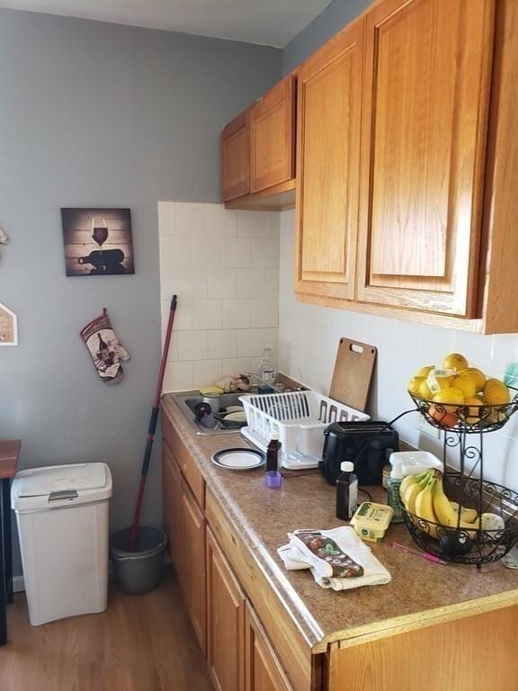 kitchen with light hardwood / wood-style floors and backsplash