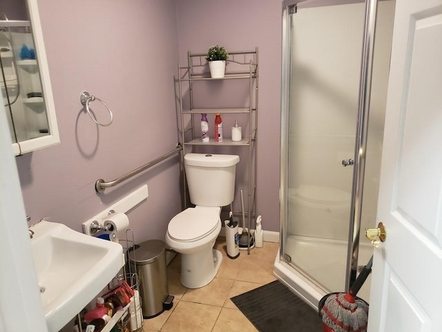 bathroom with tile patterned flooring, toilet, sink, and walk in shower