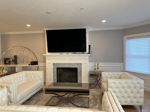 living room with crown molding, a fireplace, and hardwood / wood-style floors