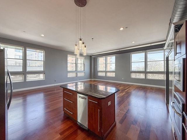 kitchen featuring baseboards, open floor plan, dark wood finished floors, and appliances with stainless steel finishes