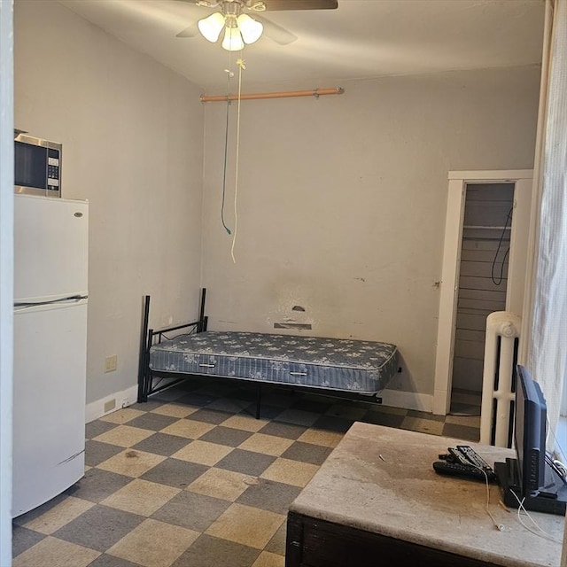 bedroom featuring a closet, ceiling fan, and white fridge