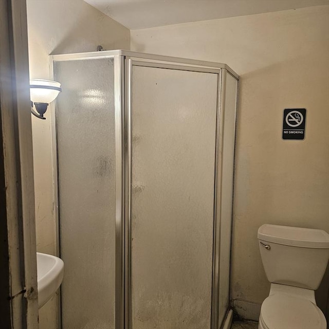 bathroom featuring toilet and an enclosed shower