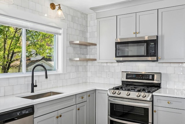 50 Mckinley St Unit 50, Maynard, MA 01754 - kitchen with stainless steel appliances, a sink, gray cabinetry, backsplash, and light countertops