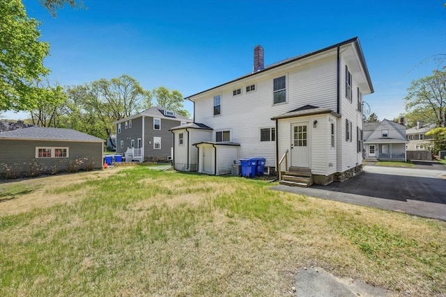 50 Mckinley St Unit 50, Maynard, MA 01754 - back of property with entry steps, a chimney, and a lawn
