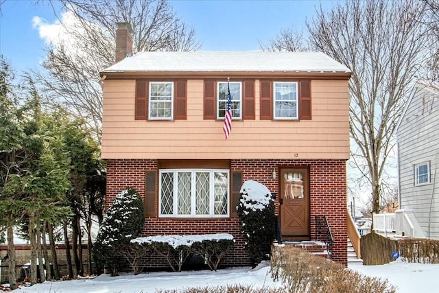 colonial house with brick siding and a chimney