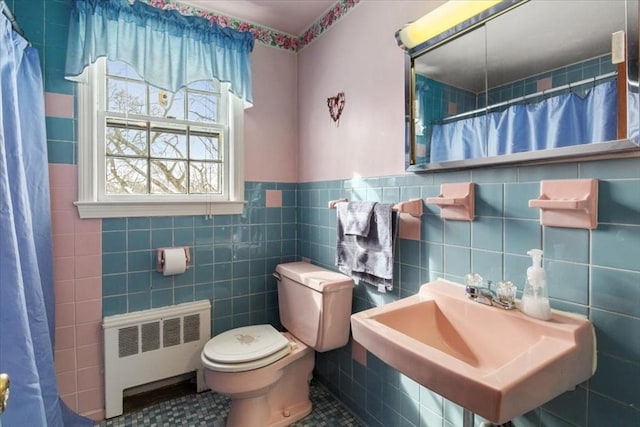 bathroom featuring toilet, a sink, tile walls, a shower with curtain, and radiator