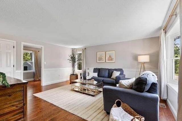 151 Whitehall Rd, Amesbury, MA 01913 - living area featuring healthy amount of natural light, dark wood-style floors, and wainscoting
