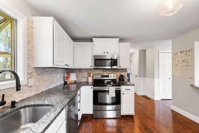 151 Whitehall Rd, Amesbury, MA 01913 - kitchen featuring stainless steel appliances, dark wood-type flooring, white cabinetry, and dark stone countertops