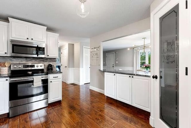 151 Whitehall Rd, Amesbury, MA 01913 - kitchen with appliances with stainless steel finishes, dark countertops, dark wood-style flooring, and white cabinetry