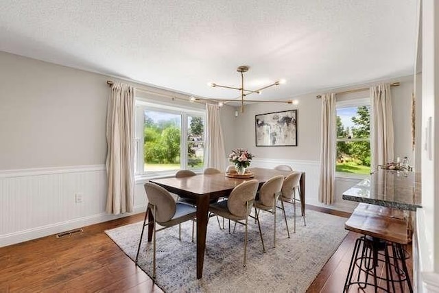 151 Whitehall Rd, Amesbury, MA 01913 - dining space with hardwood / wood-style floors, a chandelier, wainscoting, and a textured ceiling