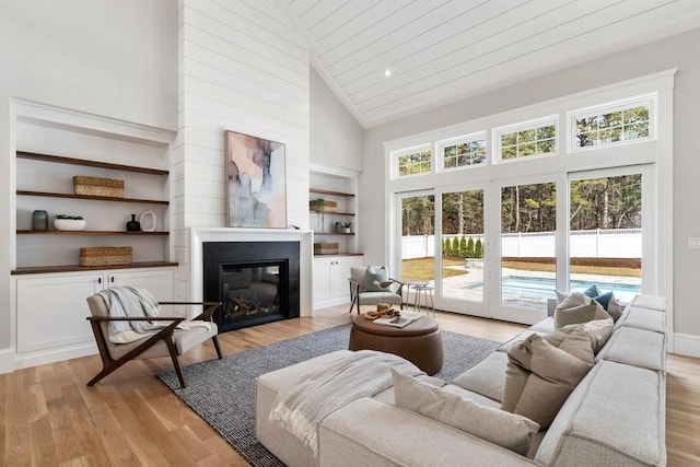 10 Dawson Way, Falmouth, MA 02536 - living room with light wood-style flooring, a glass covered fireplace, built in features, high vaulted ceiling, and wooden ceiling