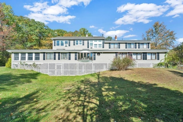 rear view of property featuring a sunroom and a yard
