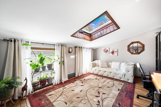 living area with plenty of natural light, wood finished floors, and a skylight
