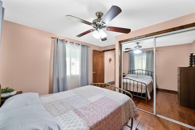 bedroom with ceiling fan, multiple windows, hardwood / wood-style flooring, and a closet