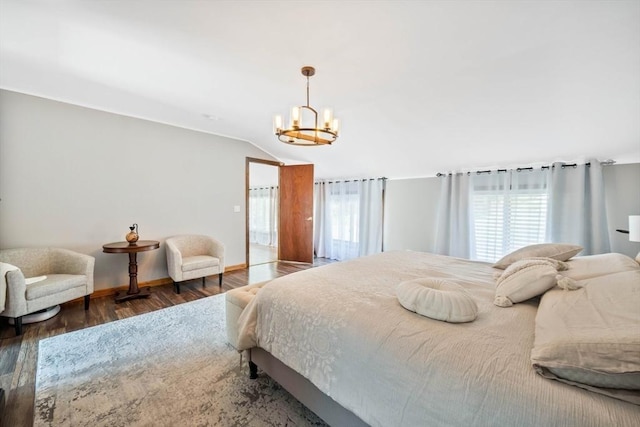 bedroom featuring a notable chandelier, multiple windows, wood finished floors, and vaulted ceiling