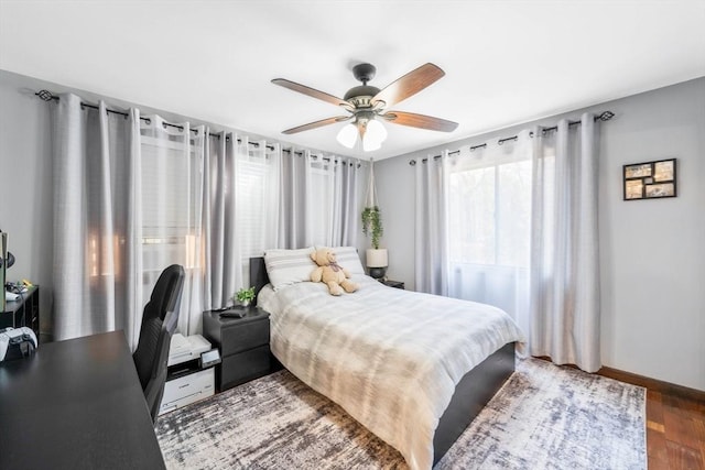 bedroom featuring baseboards, ceiling fan, and wood finished floors