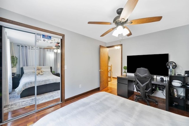 bedroom with baseboards, a ceiling fan, a closet, and wood finished floors