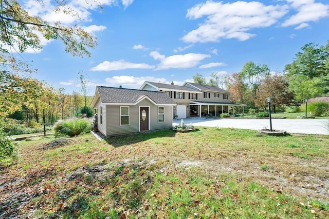 view of front of home with driveway, a front lawn, and a carport