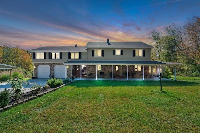 view of front of home featuring an attached garage, a patio area, a yard, and concrete driveway