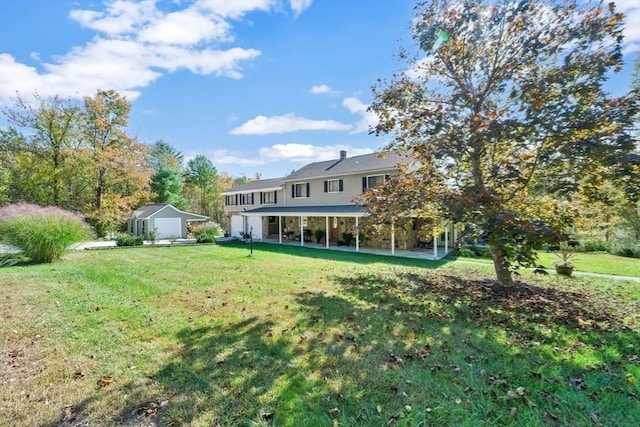 rear view of property with a yard, a patio, an outbuilding, and a storage shed