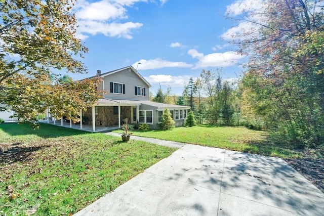view of front of property with a patio, a front lawn, and a chimney