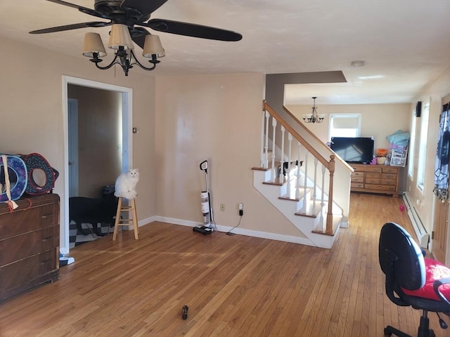 interior space featuring a baseboard heating unit, ceiling fan with notable chandelier, and light hardwood / wood-style floors