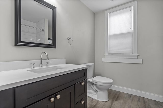 bathroom with toilet, vanity, and hardwood / wood-style flooring