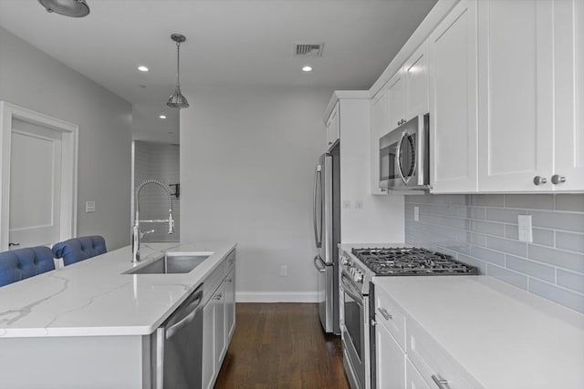 kitchen with white cabinets, appliances with stainless steel finishes, hanging light fixtures, and sink