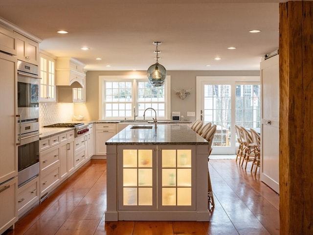 205 Powder Point Ave, Duxbury, MA 02332 - kitchen featuring a healthy amount of sunlight, glass insert cabinets, dark stone counters, and stainless steel appliances