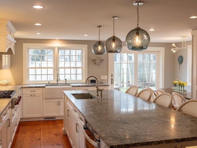 205 Powder Point Ave, Duxbury, MA 02332 - kitchen featuring a center island with sink, a sink, visible vents, and light wood-type flooring