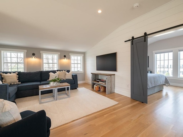 205 Powder Point Ave, Duxbury, MA 02332 - living room featuring a wealth of natural light, vaulted ceiling, a barn door, and light wood-style floors