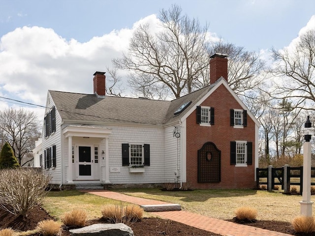 205 Powder Point Ave, Duxbury, MA 02332 - traditional-style house featuring a chimney, fence, a shingled roof, and a front yard