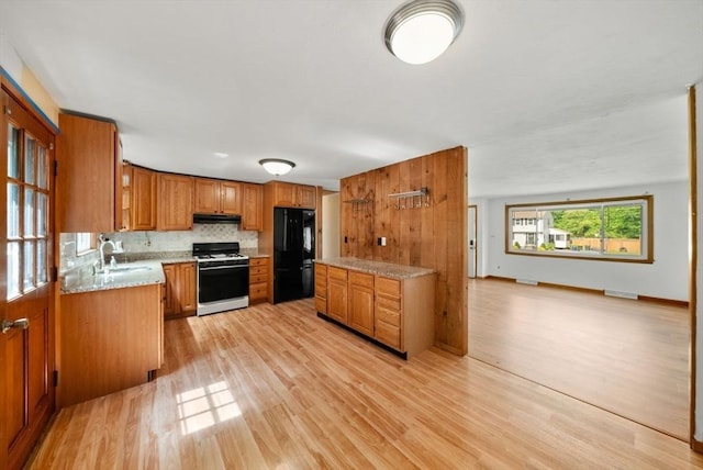 52 Richard Rd, Hanson, MA 02341 - kitchen featuring range with gas stovetop, freestanding refrigerator, light wood-style floors, brown cabinets, and light countertops