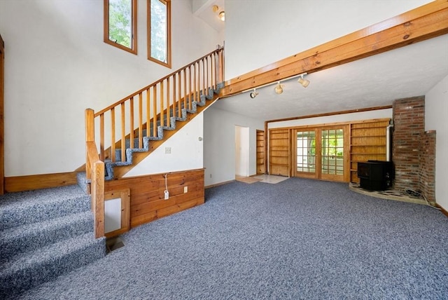 52 Richard Rd, Hanson, MA 02341 - unfurnished living room with carpet flooring, stairway, and a wood stove
